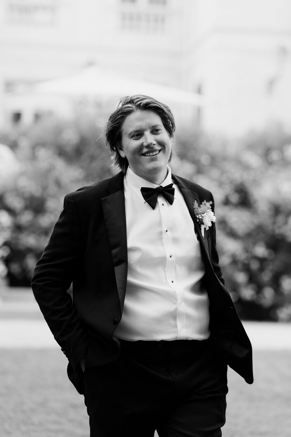 Black and white photo series showing a candid moment of someone in a tuxedo laughing outdoors.