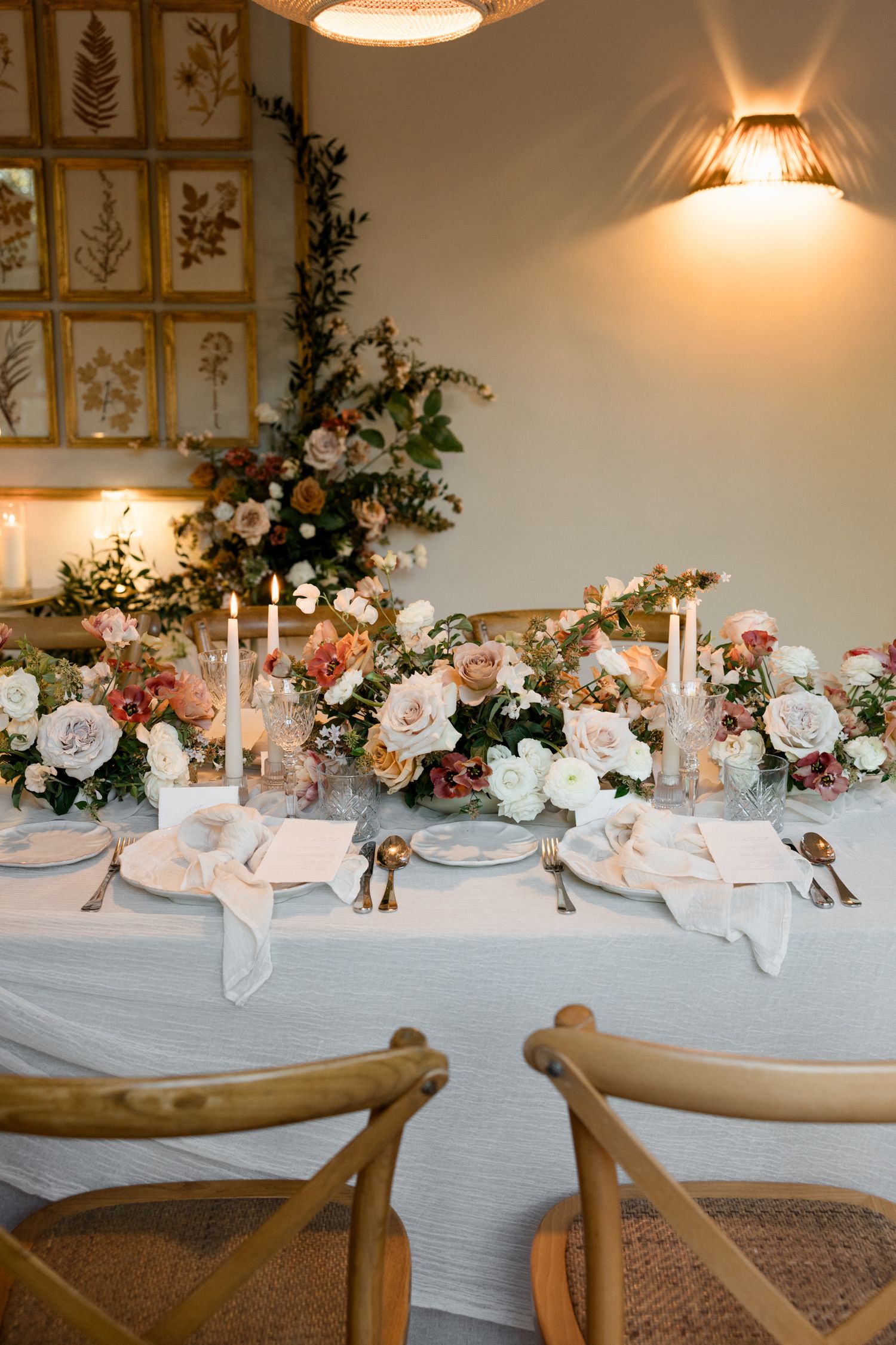 Elegant wedding reception table with soft blue linens, floral centerpieces, and glowing candlelight creates romantic ambiance.