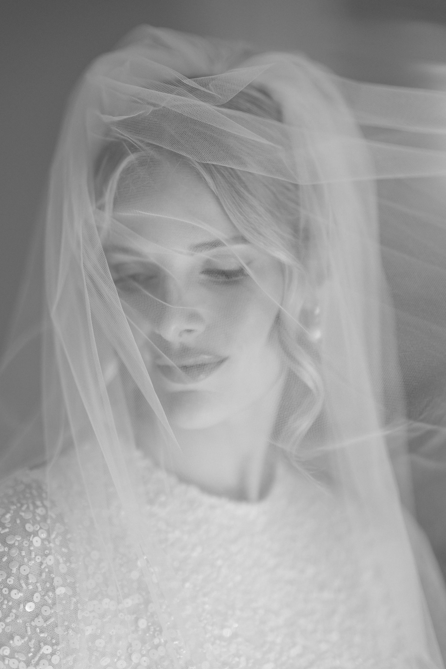 A series of ethereal black and white bridal portraits showing a figure in a wedding veil and lace dress. editorial wedding photographer