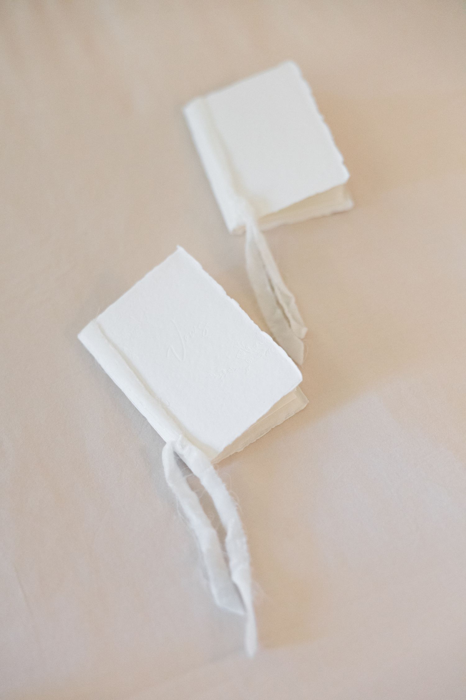 White paper squares arranged in a minimalist composition on a beige background creating a subtle shadow effect.