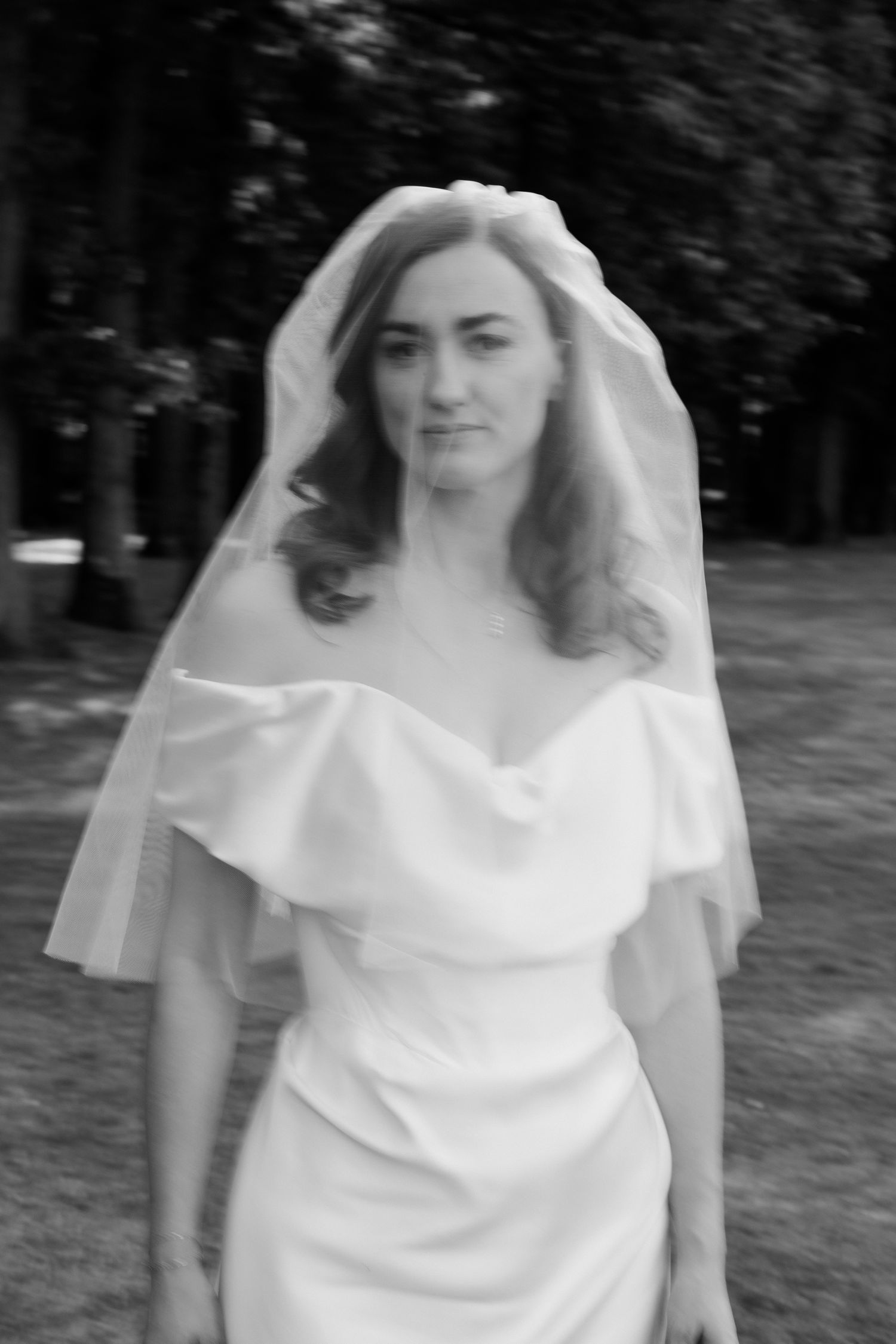 A bride in a flowing white wedding dress poses outdoors in a series of candid shots in a park setting. Luxury wedding france