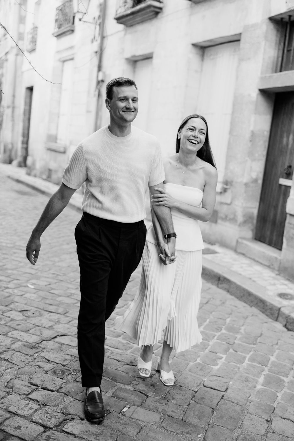 Stylish couple walking on cobblestone streets in black and white photography. Seance couple Tours