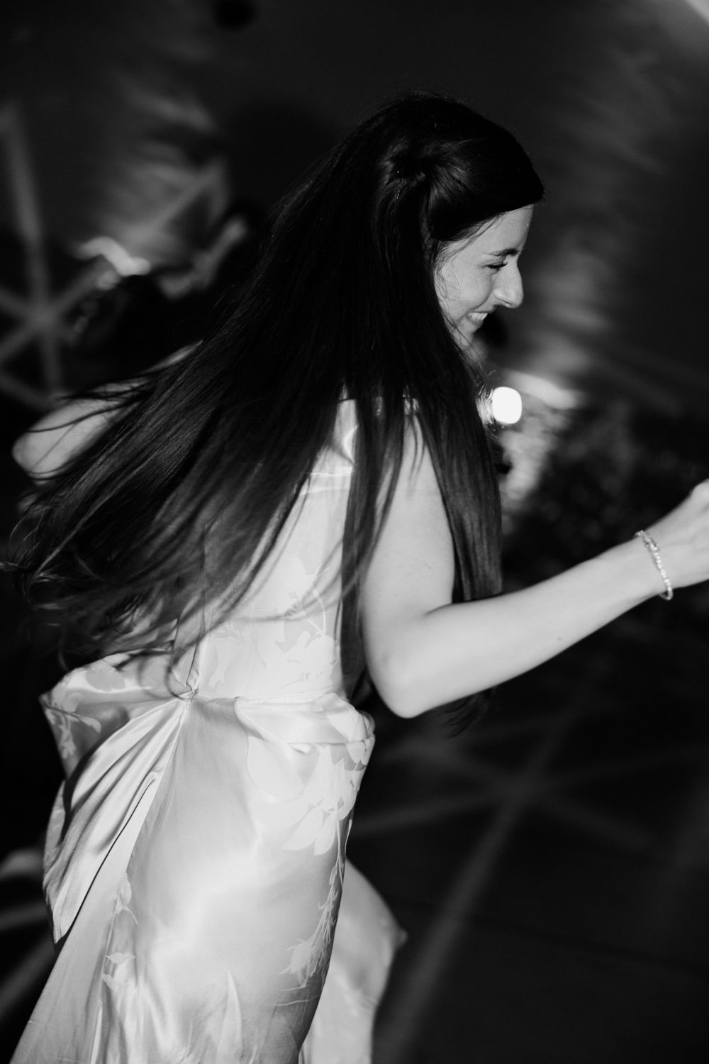 A series of artistic black and white images showing a person in a white dress with dark hair creating movement while dancing.