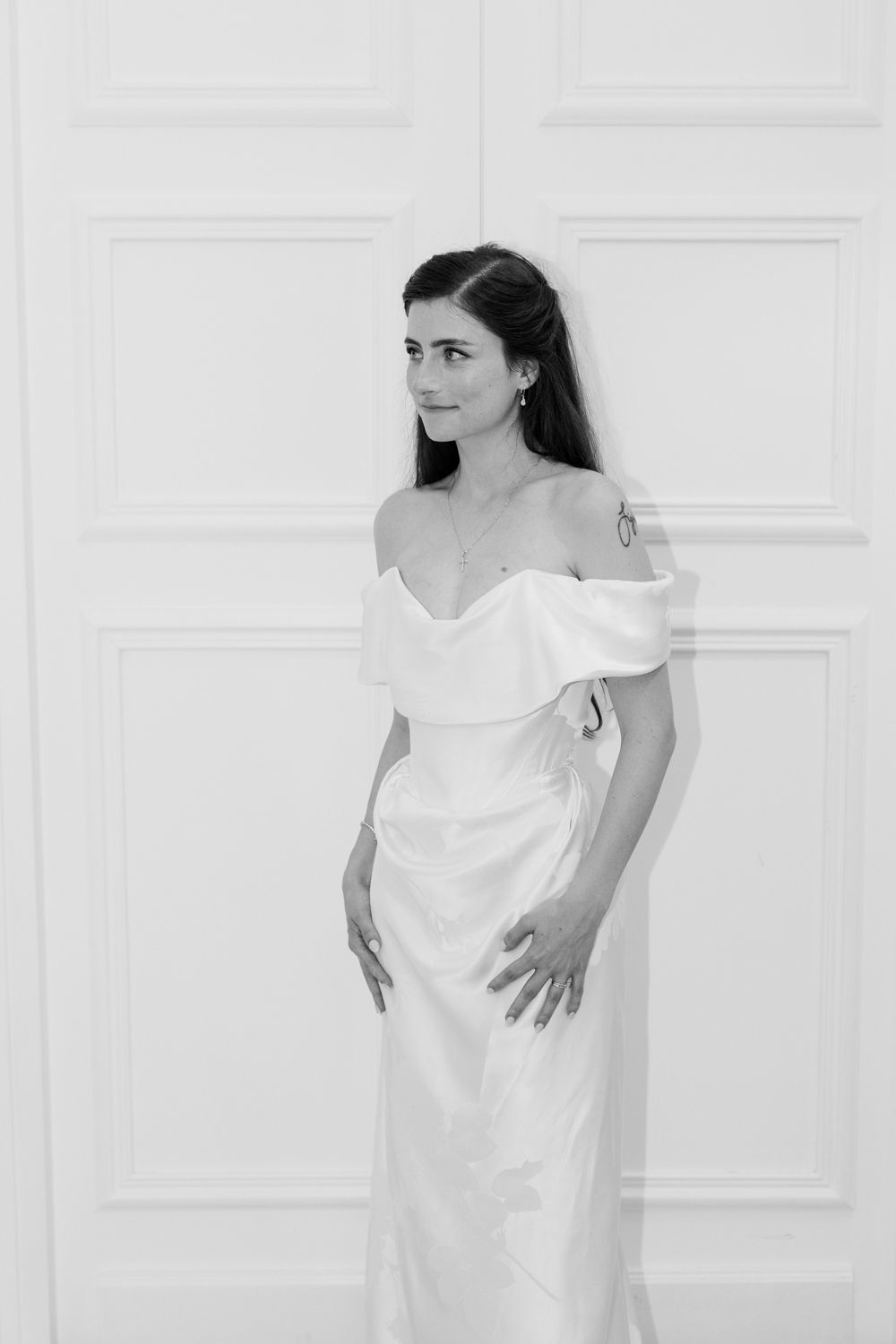 Black and white photograph series showing a white flowing dress against a light background in different poses and angles.