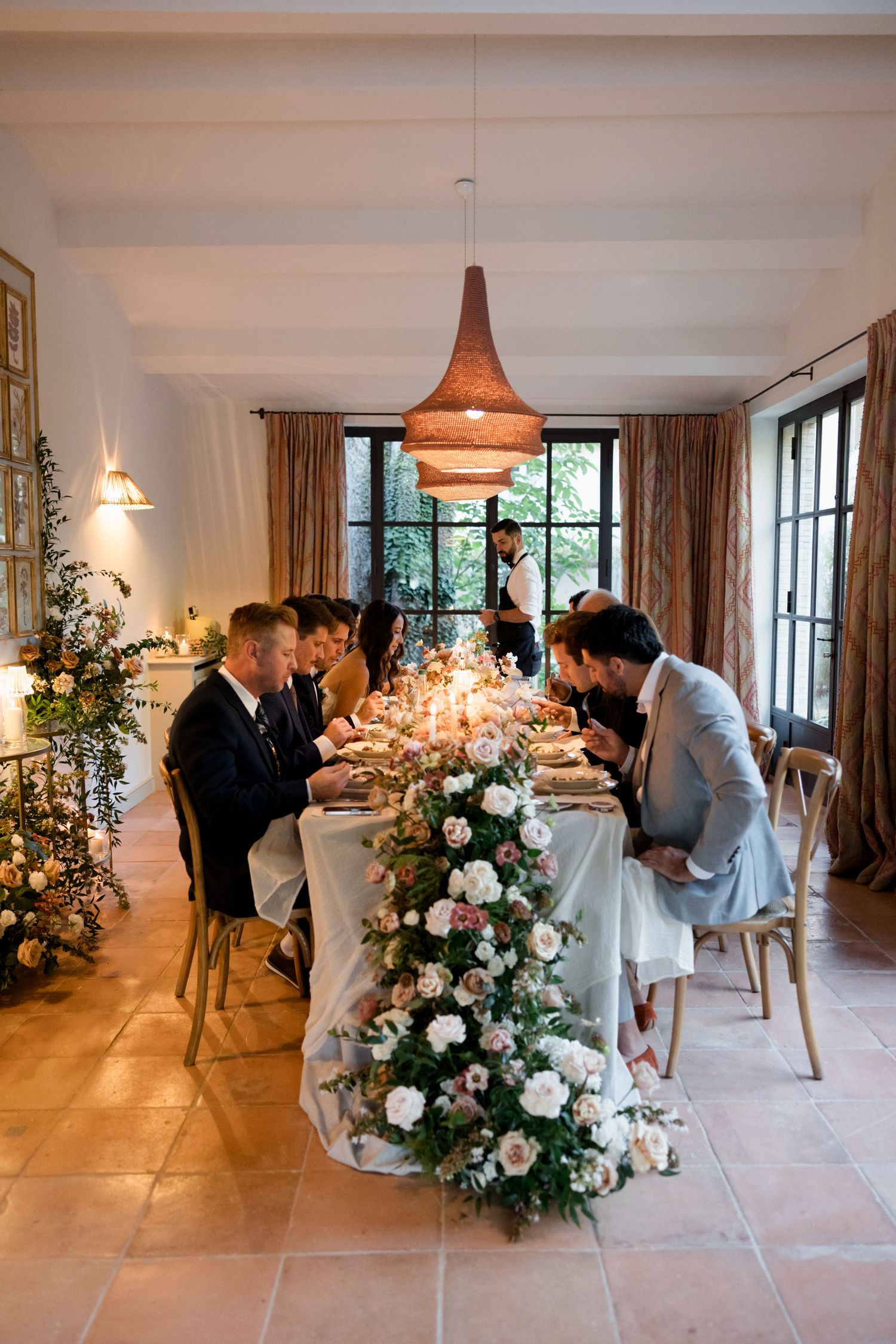 Wedding photographers capture candid moments during an elegant indoor reception with floral arrangements and natural lighting. wedding photo