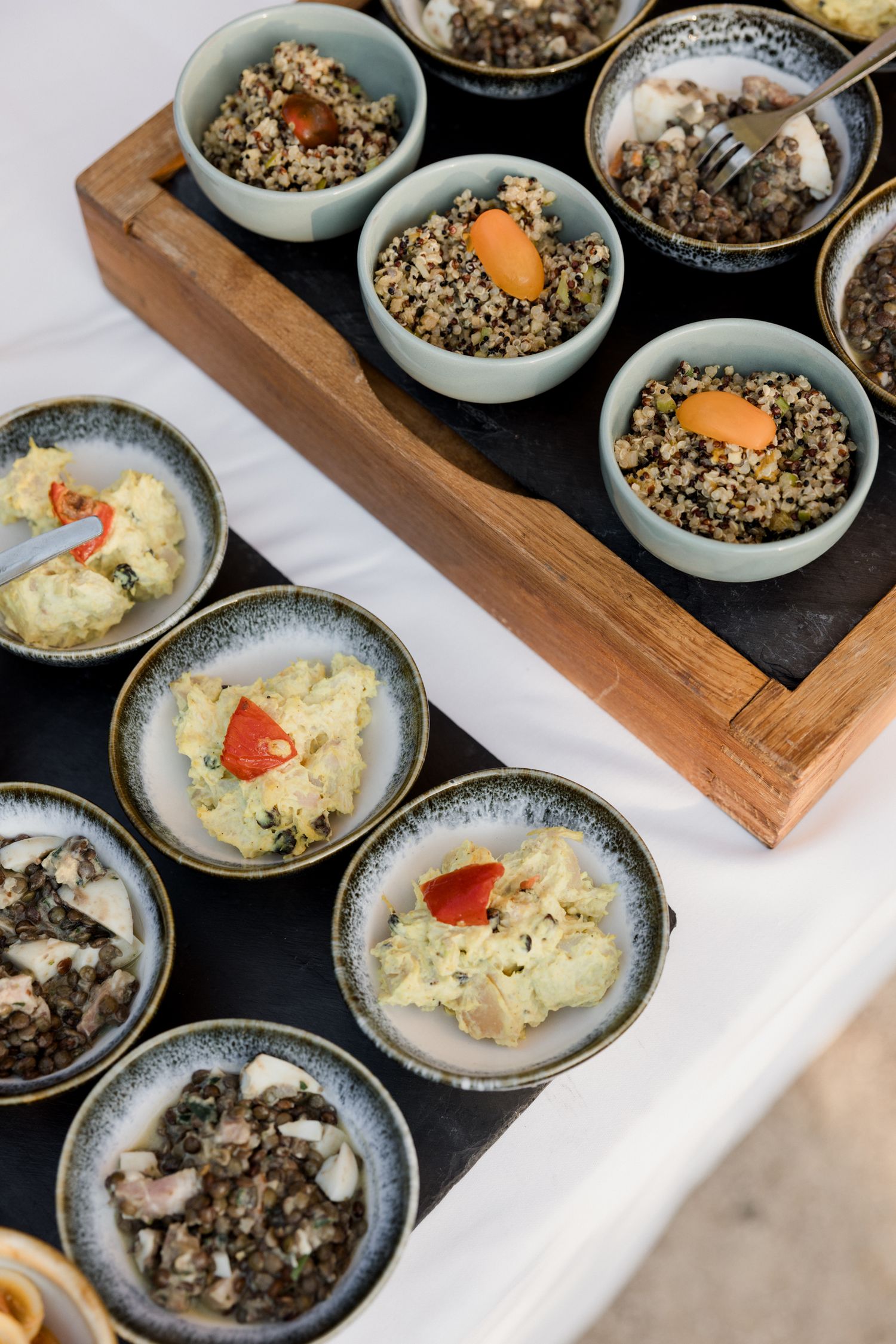 Elegant ceramic bowls arranged on wooden boards featuring risotto with colorful garnishes and savory side dishes.