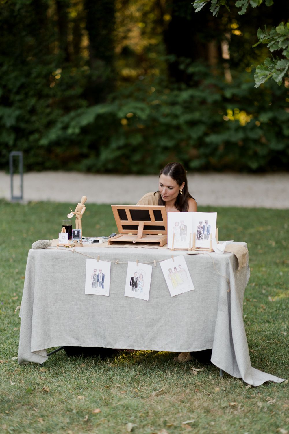 A series of photos showing a memorial or guest book signing table setup outdoors with a white tablecloth on grass. Aurora Artiste