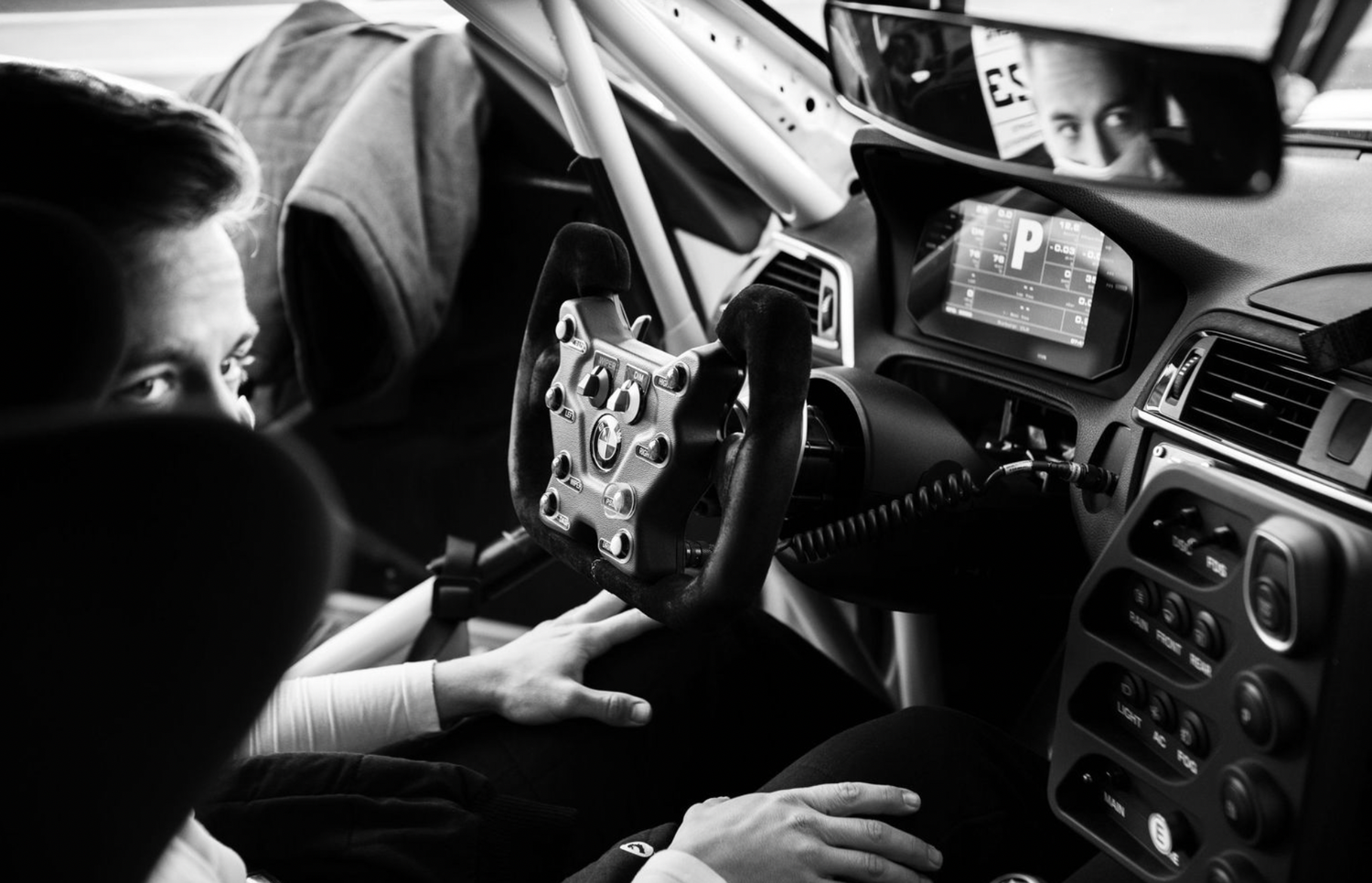 Black and white photo showing interior of police car with radio equipment and dashboard controls.