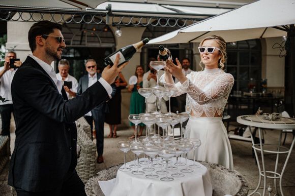 Feierlicher Moment, während der Champagnerturm im Freien gefüllt wird – festliche Stimmung beim heiraten im Morrhof.