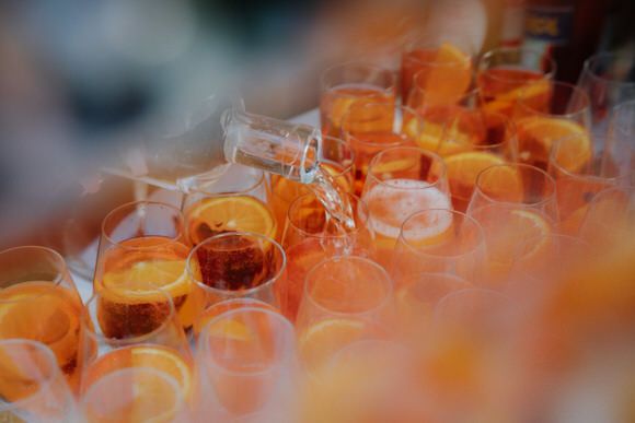 Hochzeitsfotograf Boudier & Koeller – Reihen von orangenen und roten Cocktails bei Catering-Event, unscharfer Hintergrund.
