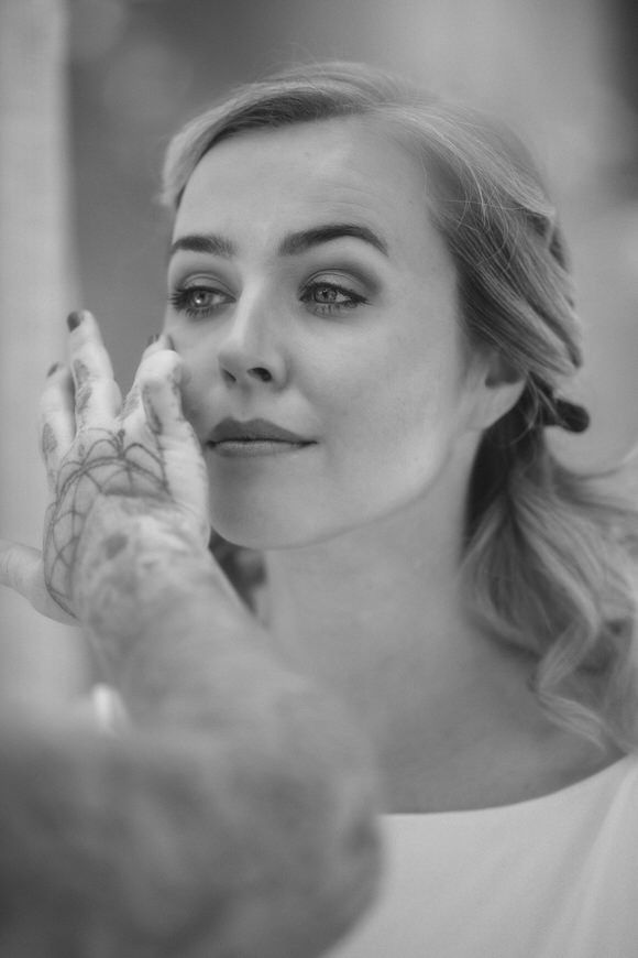 Schwarz-Weiß-Portrait zeigt zarte Make-up-Applikation – natürliche Schönheit beim heiraten im Morrhof.