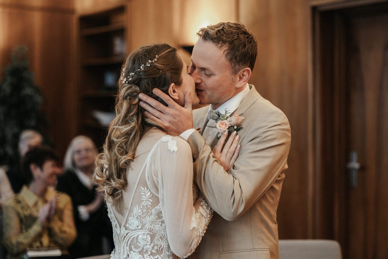 A romantic first kiss between newlyweds during their indoor wedding ceremony.