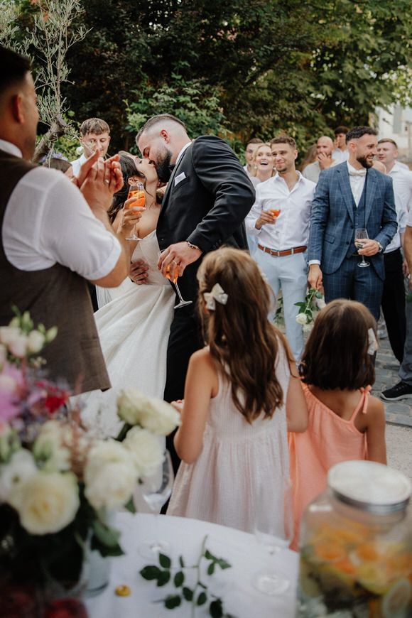 Hochzeitsfotograf Boudier & Koeller – Gäste feiern draußen bei eleganter Gartenhochzeit mit Toast.