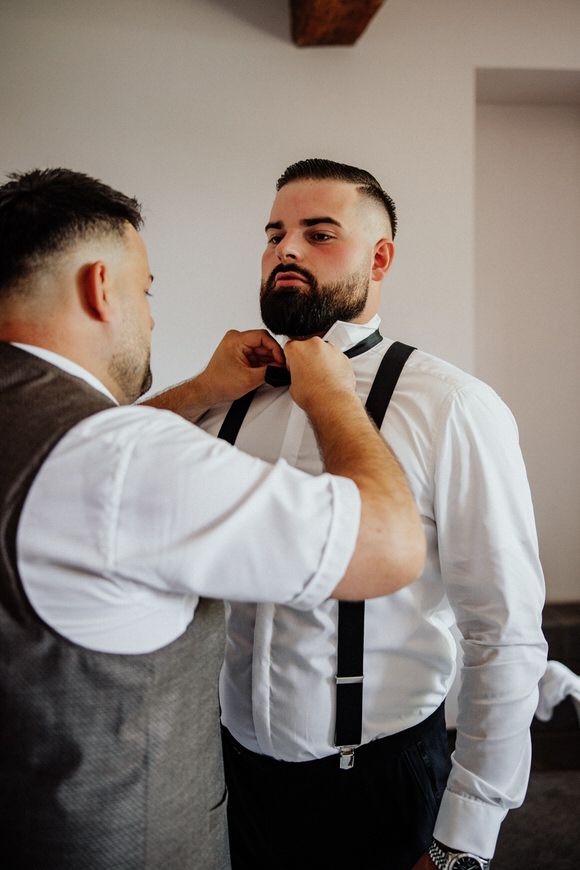 A sequence of photos showing someone adjusting a black tie and bowtie on a person wearing a white dress shirt.