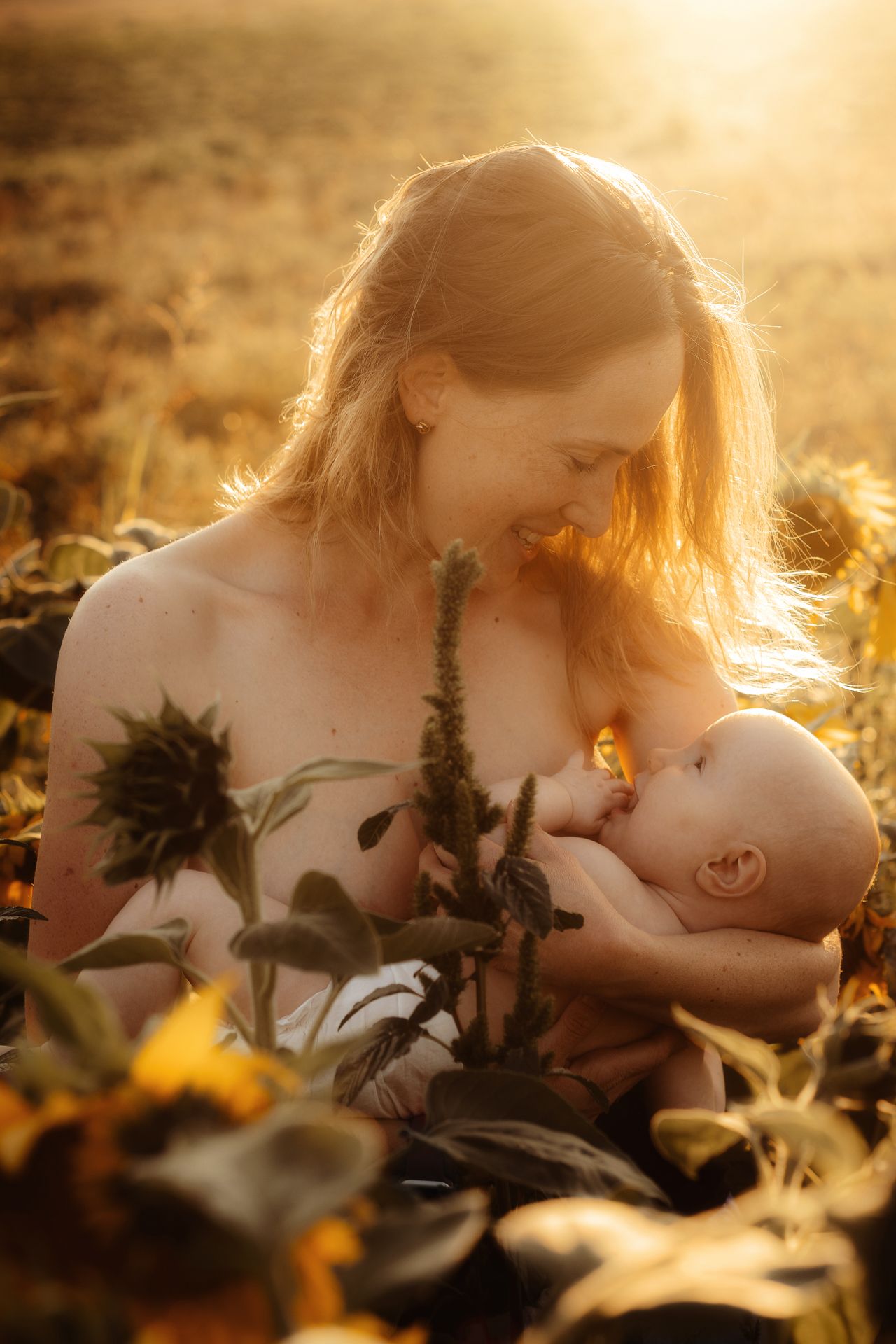 A romantic couple embraces in a sunlit meadow surrounded by wildflowers during golden hour.