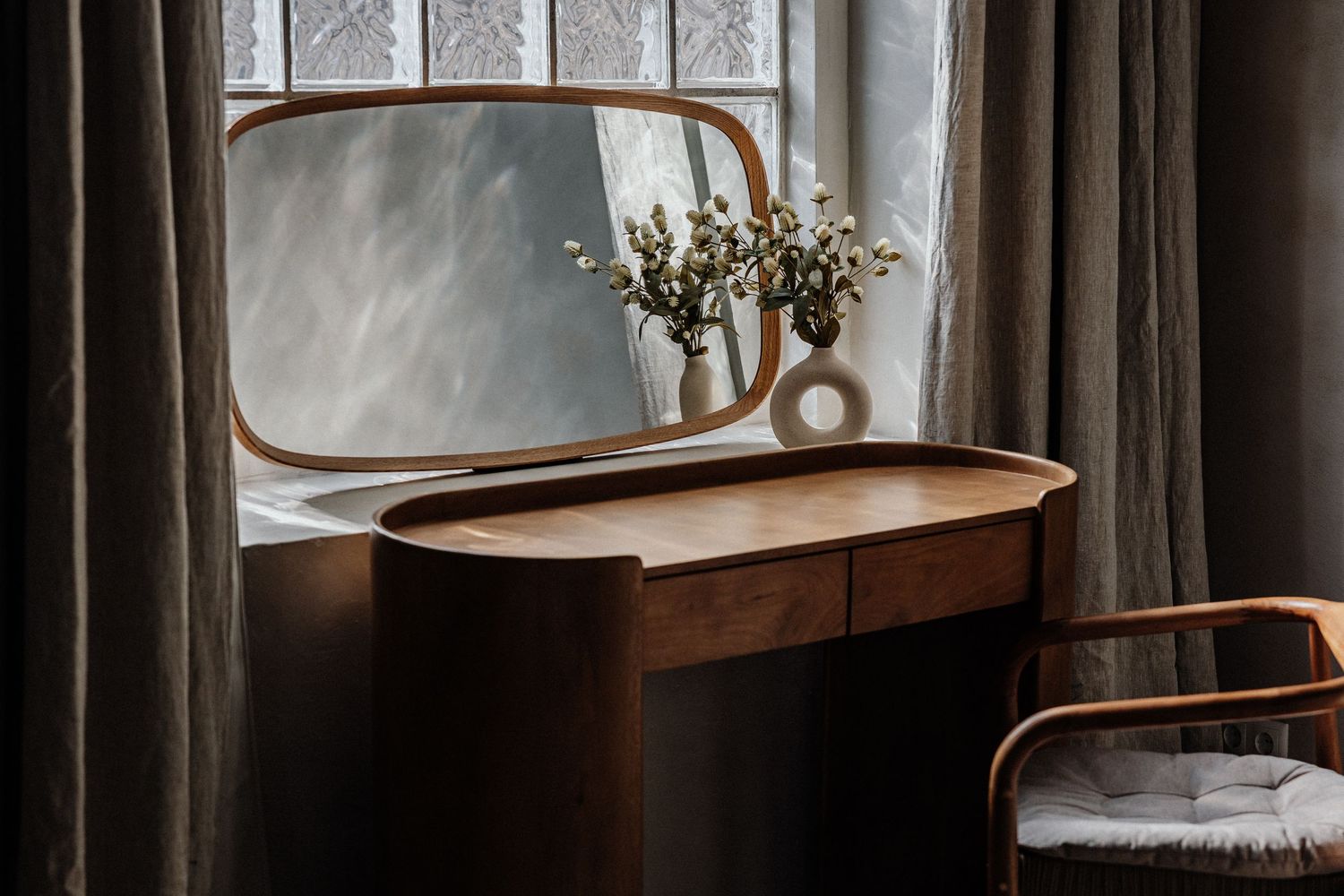 Vintage Holz-Frisiertisch mit rundem Spiegel & getrockneten Blumen am Fenster mit grauen Vorhängen – Business Shooting Frankfurt