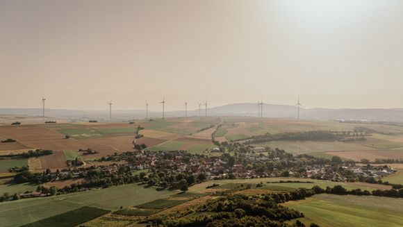 Hochzeitsfotograf Boudier & Koeller – Panoramablick auf sanfte Hügel und landwirtschaftliche Flächen unter bewölktem Himmel.