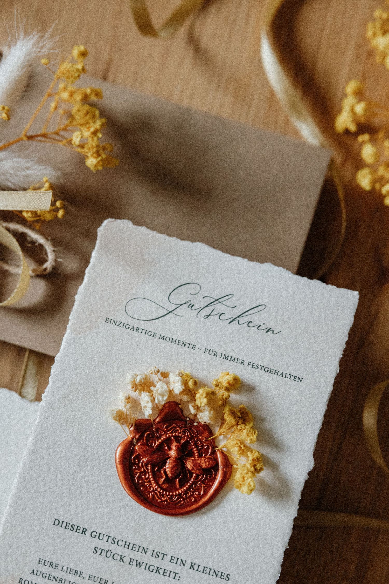 Vintage paper documents with red wax seals and gold decorative elements arranged on a wooden surface.