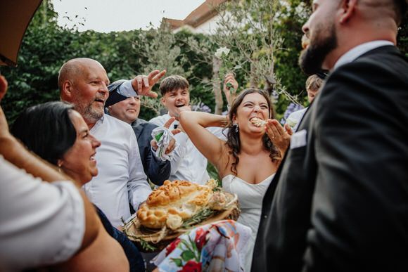 Hochzeitsfotograf Boudier & Koeller – Gäste feiern mit traditionellem Brot während Outdoor-Hochzeitsfeier.