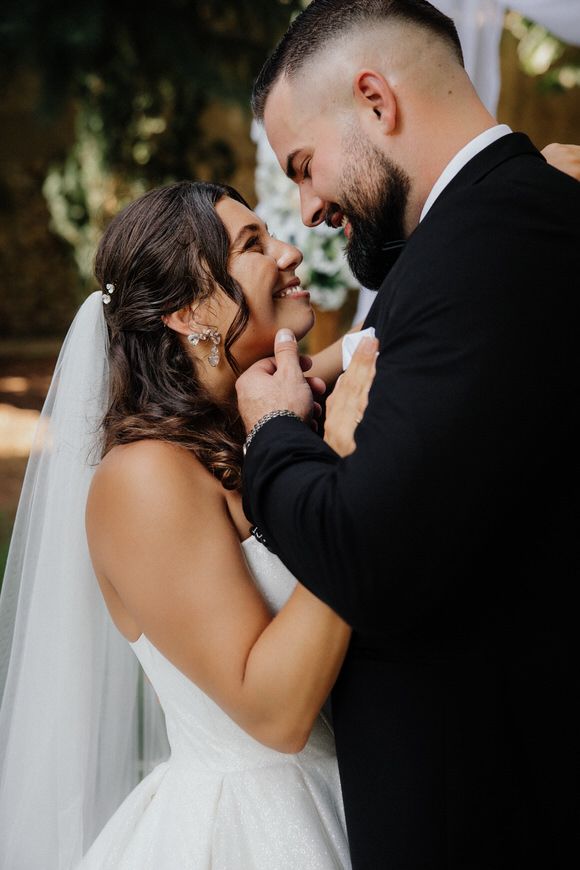 Romantic sequence of wedding couple sharing tender kisses outdoors with a flowing white veil in natural lighting.