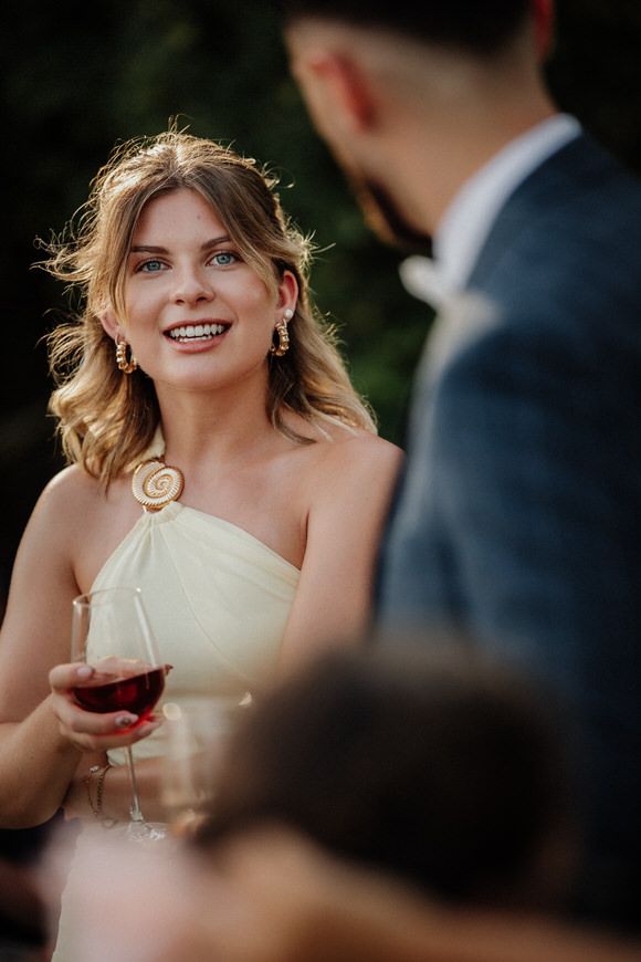 Hochzeitsfotograf Boudier & Koeller – Gast in festlicher Kleidung genießt Wein bei elegantem Outdoor-Event.