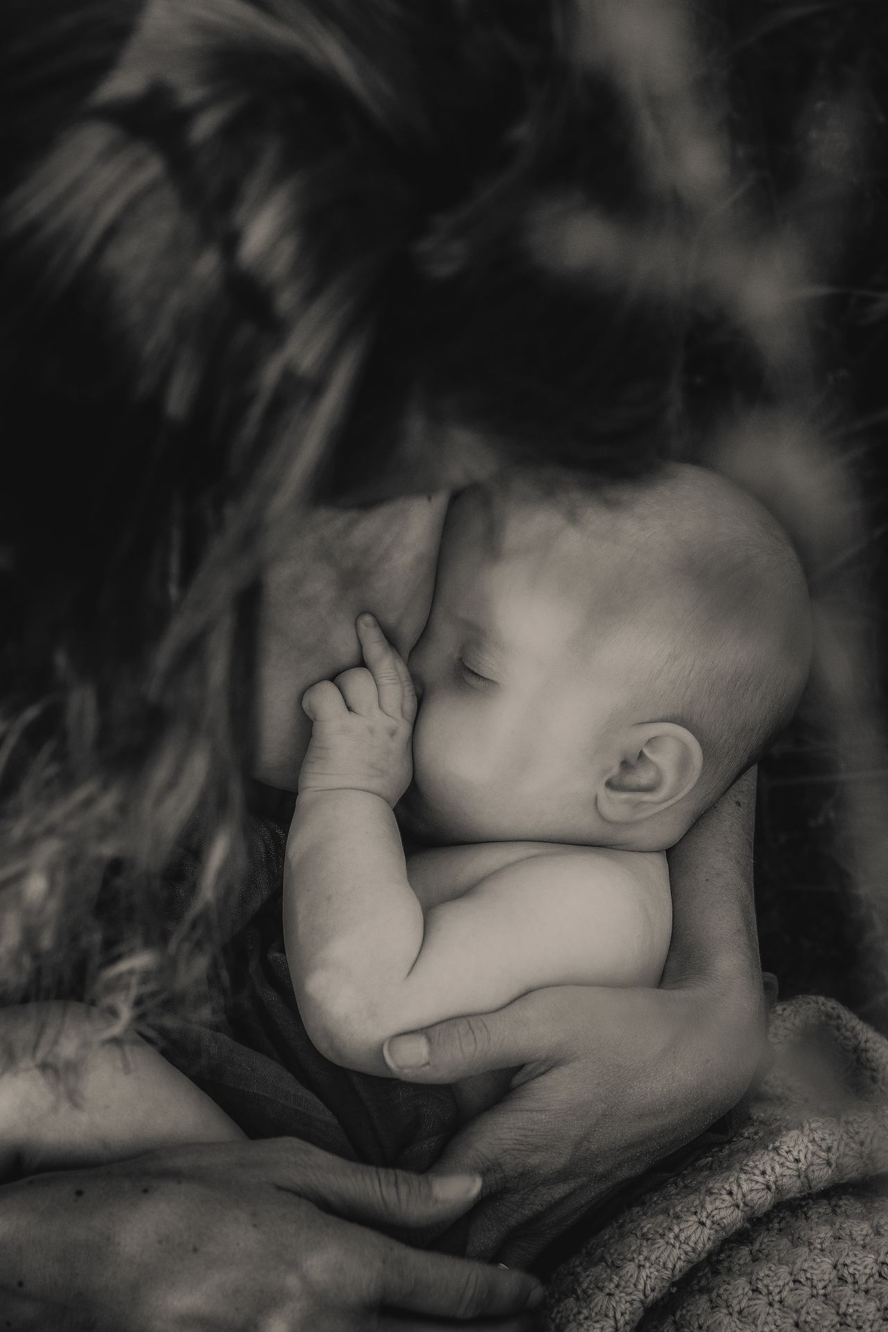 A black and white artistic photo sequence showing a baby breastfeeding in close-up profile views.