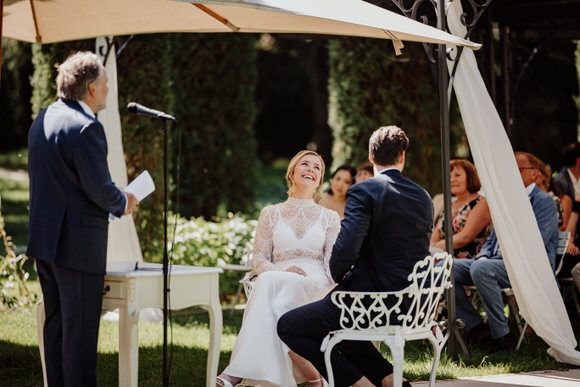 Outdoor-Trauung mit weißen Vorhängen und Stühlen unter schattigen Bäumen – romantische Zeremonie beim heiraten im Morrhof.