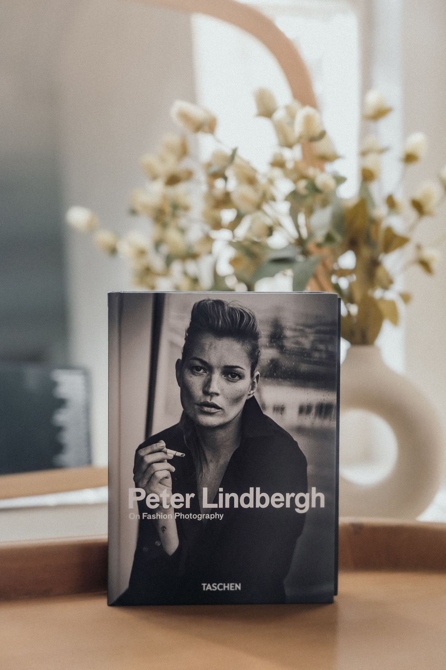 Peter Lindbergh Fotobuch von Taschen auf Holzfläche mit getrockneten Blumen – Business Shooting Frankfurt