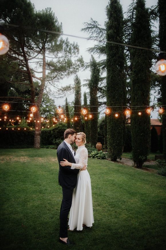 Abendliche Gartenzeremonie mit Lichterketten und hohen Zypressen – romantisch heiraten im Morrhof.