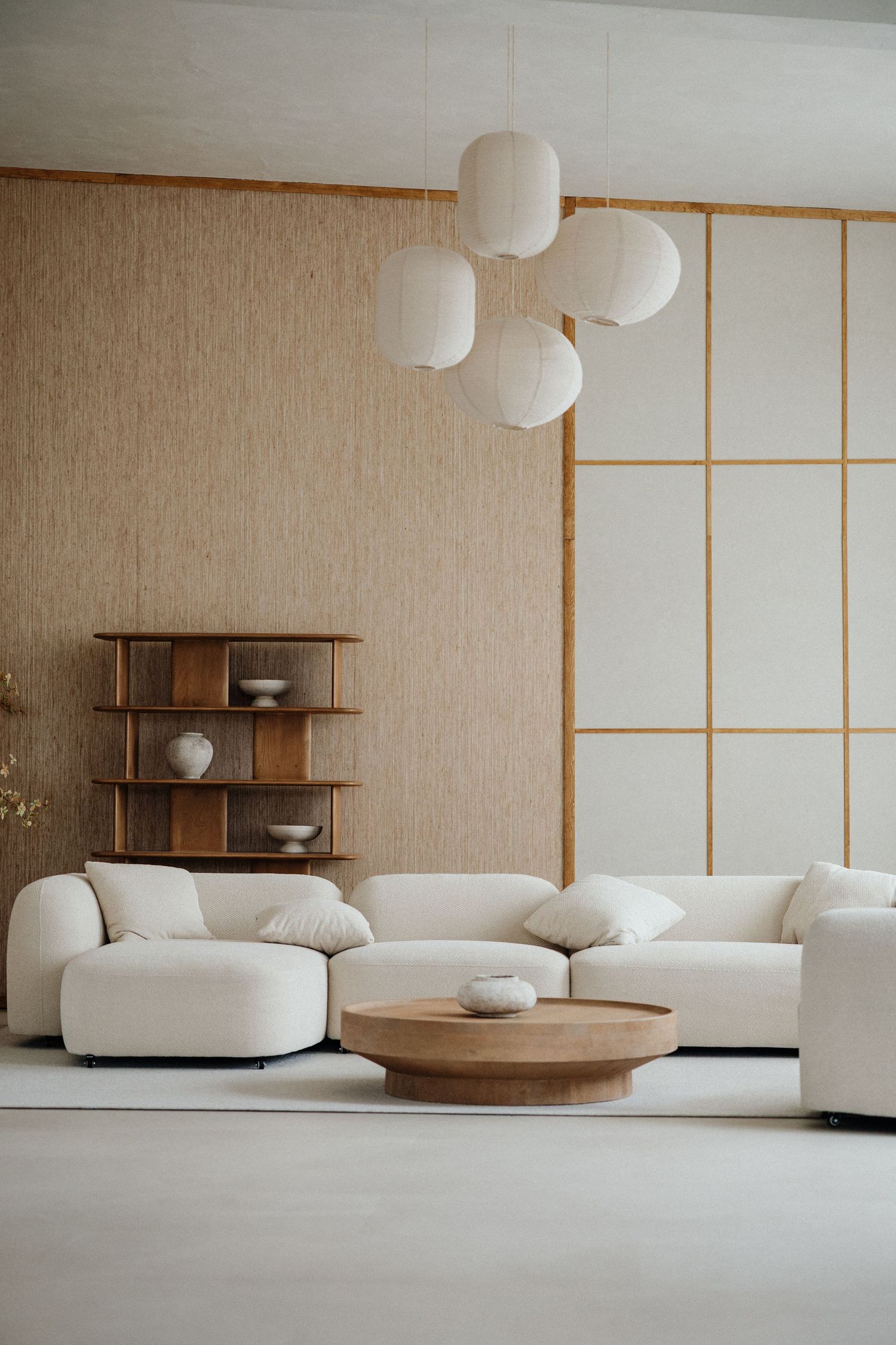 Modernes minimalistisches Wohnzimmer mit weißem Ecksofa, rundem Holztisch & schwebenden Papierlampen – Business Shooting Frankfurt