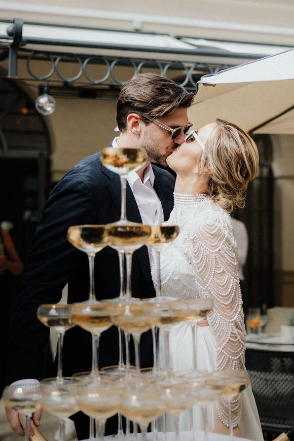 Eleganter Champagnerturm wird gefüllt, während Gäste in Abendgarderobe zusehen – exklusiv heiraten im Morrhof.
