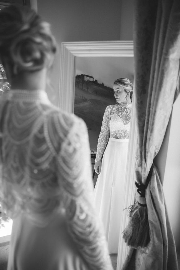 Elegantes Spitzenhochzeitskleid im Fensterlicht während der Brautvorbereitungen – romantisch heiraten im Morrhof.
