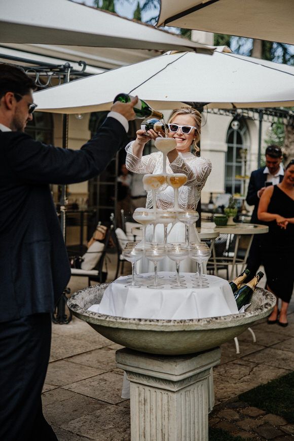 Champagnerturm auf kunstvollem Steinsockel bei eleganter Outdoor-Hochzeit – glamourös heiraten im Morrhof.