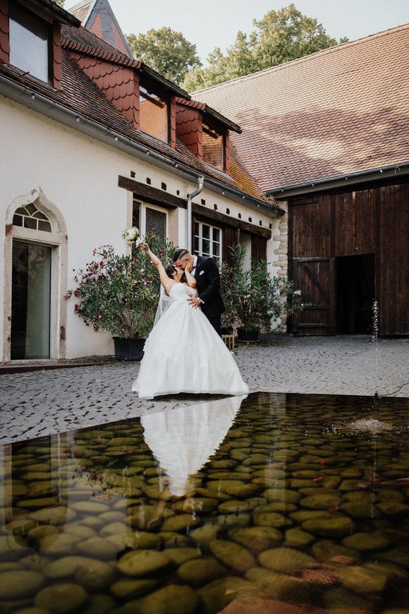 Hochzeitsfotograf Boudier & Koeller – Vier künstlerische Fotos der Braut im weißen Kleid auf Kopfsteinpflaster eines europäischen Hofs.