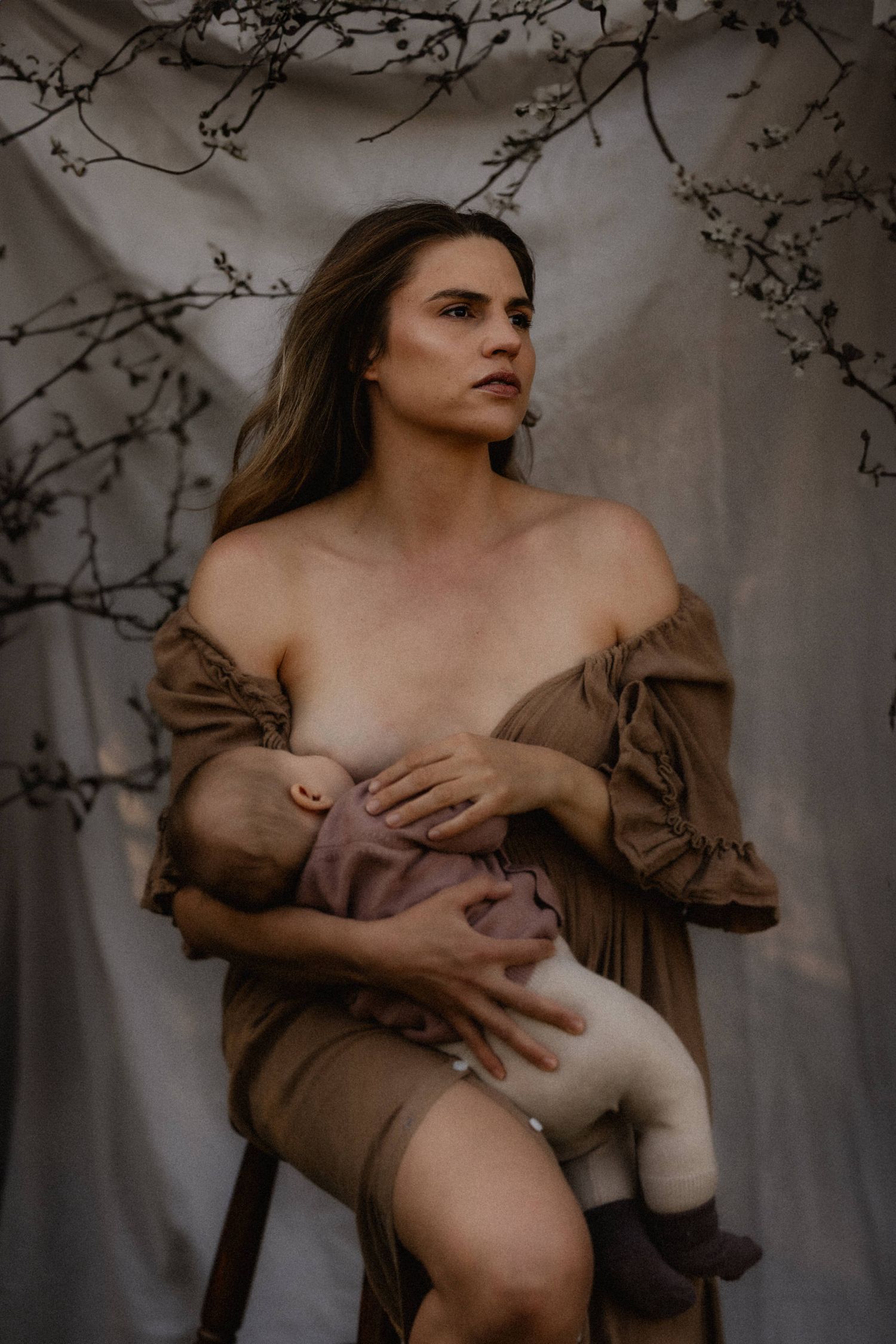 A series of artistic portraits showing a person in a brown dress against a moody, natural backdrop with branches.
