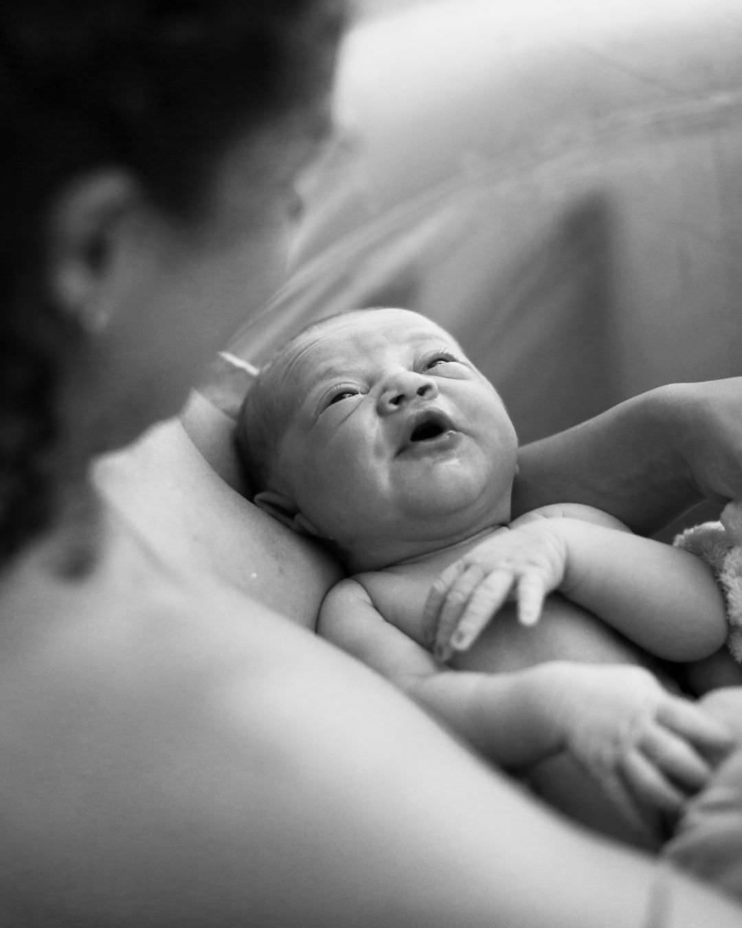 Geburtsfotografie Wiesbaden und Rhein & Main: Schwarz-Weiß-Nahaufnahme von Gesicht und Händen eines neugeborenen Babys