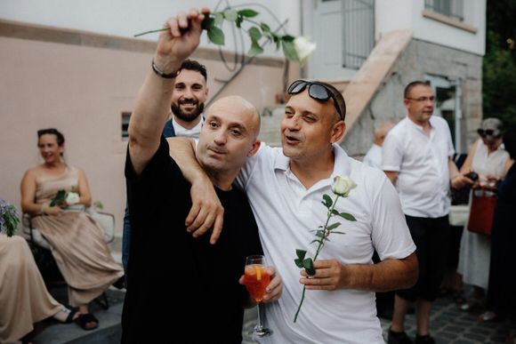 Hochzeitsfotograf Boudier & Koeller – Gäste tanzen und feiern mit grünen Pflanzenstielen bei Outdoor-Hochzeit.