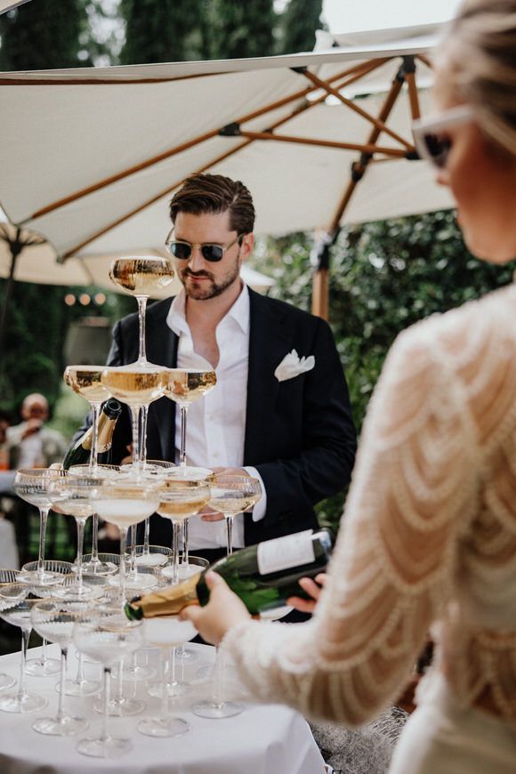 Elegante Gartenhochzeit mit Gästen rund um einen funkelnden Champagnerturm – feiern und heiraten im Morrhof.