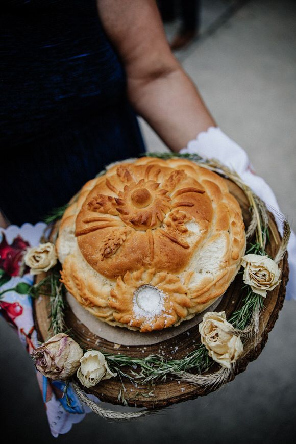 Hochzeitsfotograf Boudier & Koeller – Frisch gebackene goldene Brotringe auf rustikalen Holzplatten mit Dekoblumen.