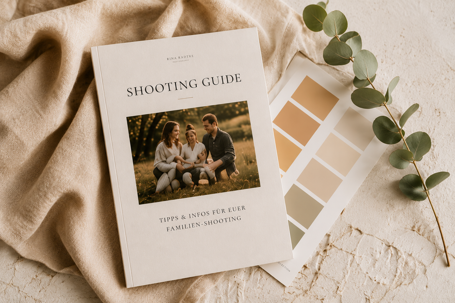 A family photography shooting guide booklet with color swatches and eucalyptus on a beige textured surface.