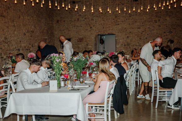 Hochzeitsfotograf Boudier & Koeller – Hochzeitslocation mit Lichterketten, langen Tischen und rustikalem Backsteininterieur.