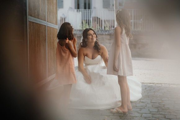 Hochzeitsfotograf Boudier & Koeller – Braut in weißem Kleid läuft die Kopfsteinpflasterstraße entlang im weichen Licht.