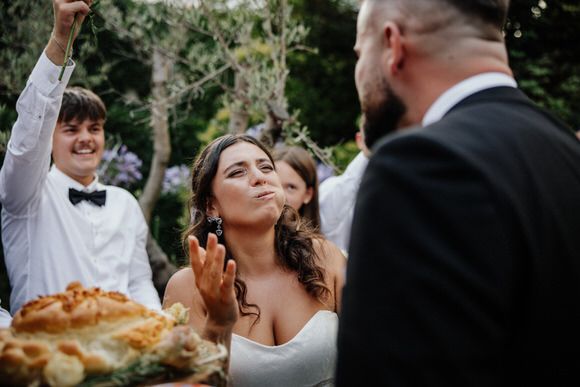 Hochzeitsfotograf Boudier & Koeller – Gäste feiern fröhlich bei Outdoor-Zeremonie um rustikalen Tisch mit Speisen.