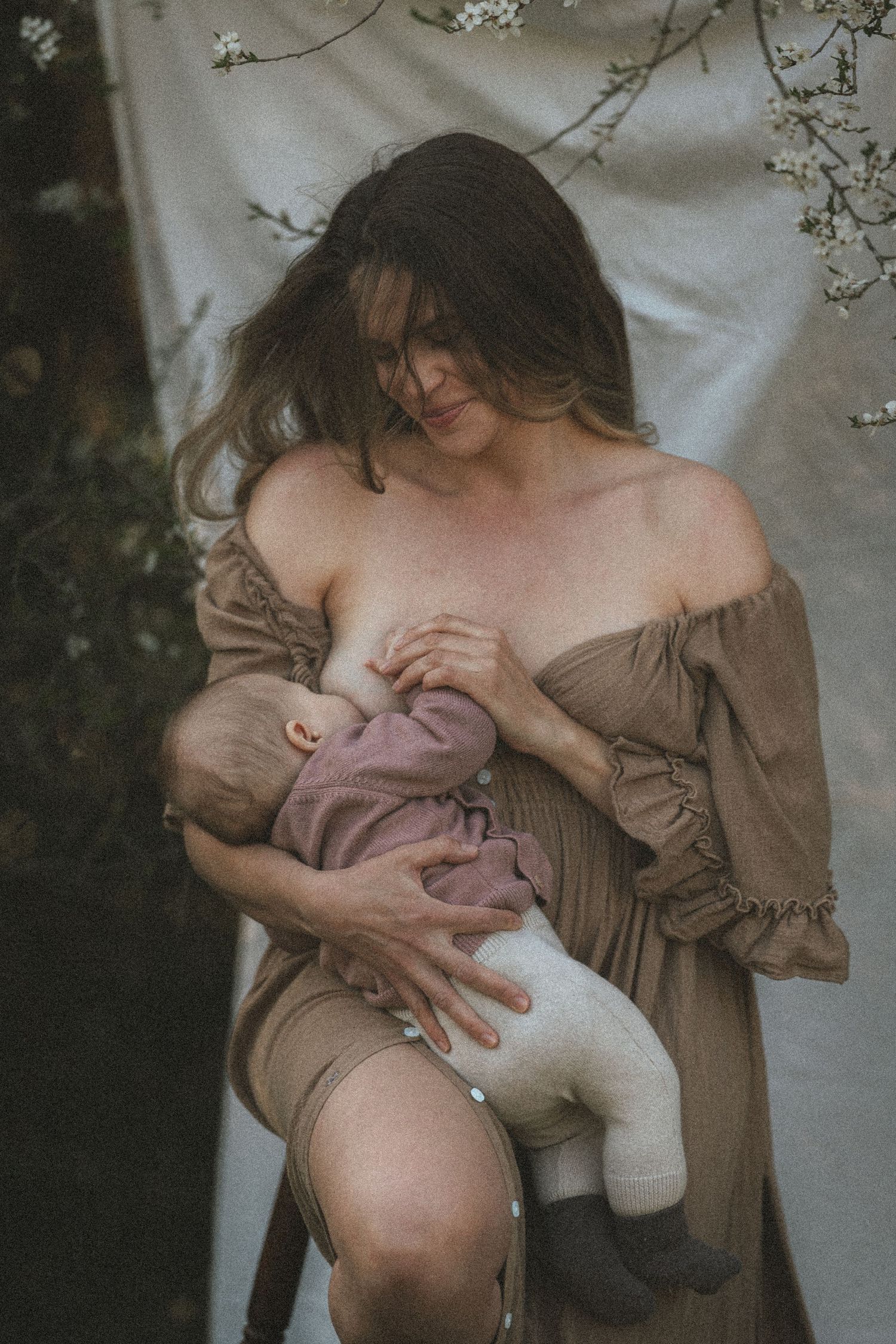 A series of intimate breastfeeding moments captured in soft, natural lighting with floral elements in the background.