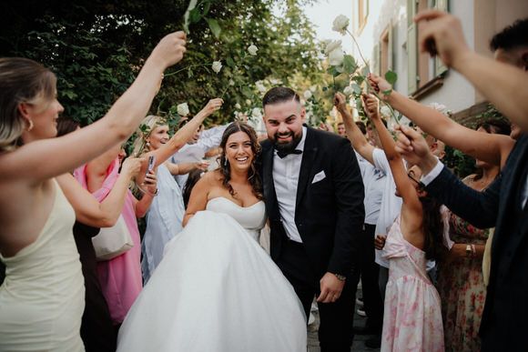 Hochzeitsfotograf Boudier & Koeller – Hochzeitsgesellschaft geht unter erhobenen Armen der Gäste hindurch.
