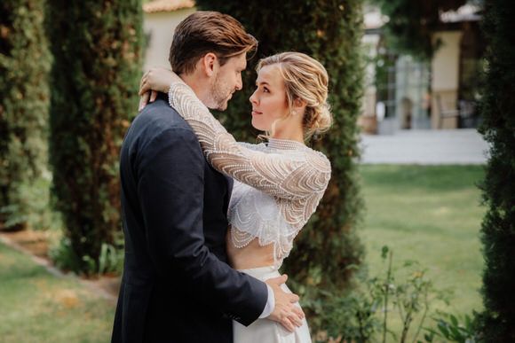 Romantische Hochzeits­portraits in üppiger Gartenkulisse mit Zypressen – elegant heiraten im Morrhof.