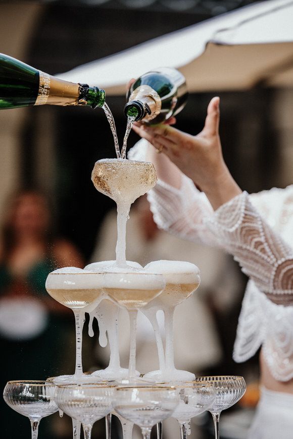 Champagner wird in gestapelte Kristallgläser bei einem eleganten Event gegossen – luxuriöse Atmosphäre beim heiraten im Morrhof.