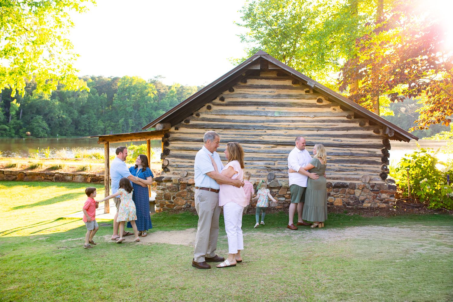 Extended family session at Yates Mill in Raleigh, NC at sunset by a log cabin
