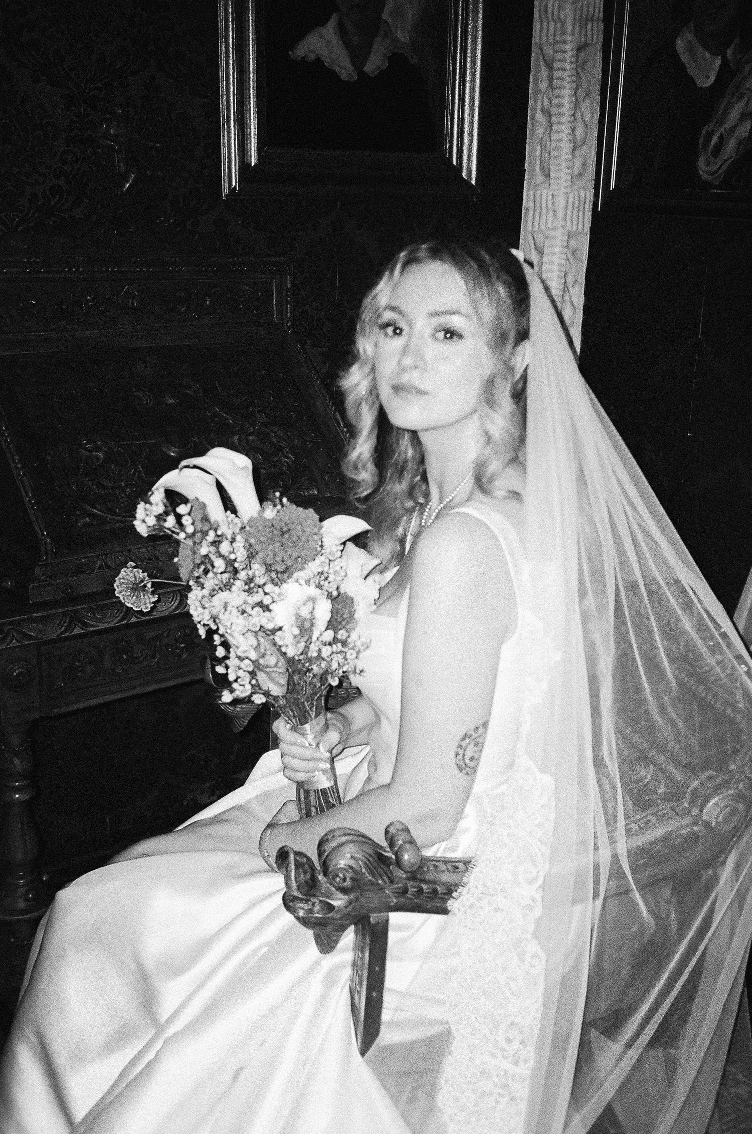 A series of black and white wedding portraits showing a bride in a white dress holding a bouquet and wearing a veil.