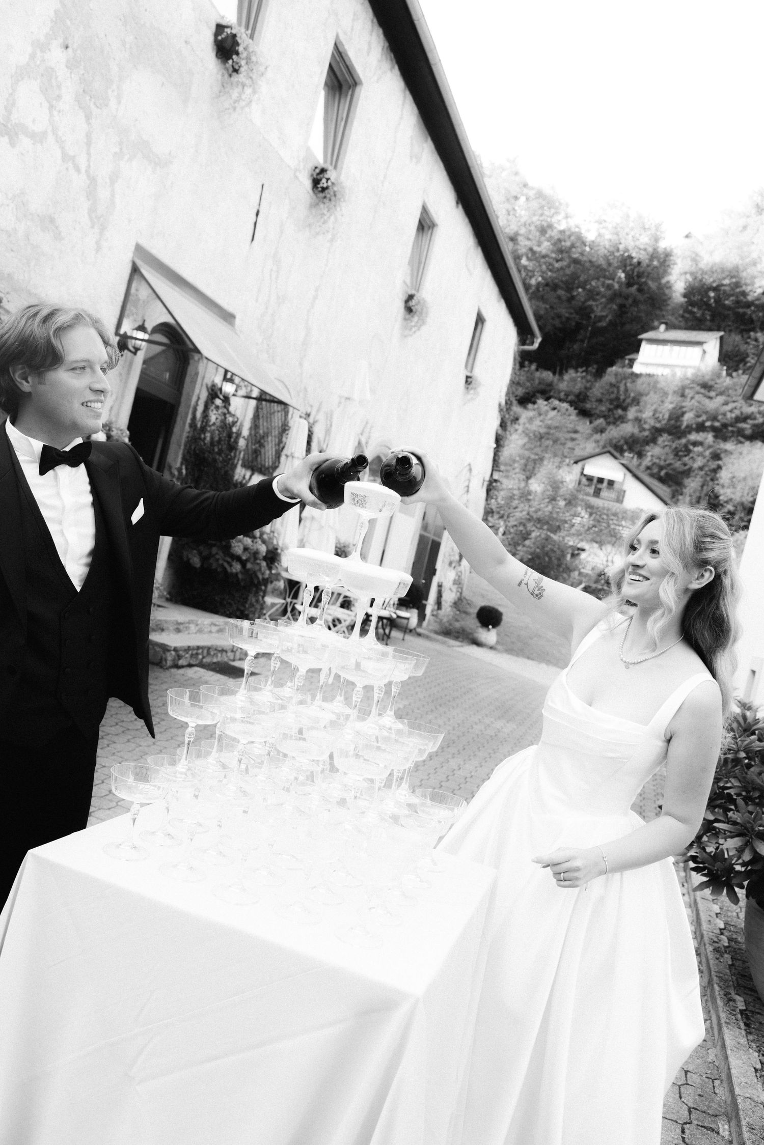 Black and white photo sequence showing a bride and groom signing their marriage documents at an outdoor wedding ceremony.
